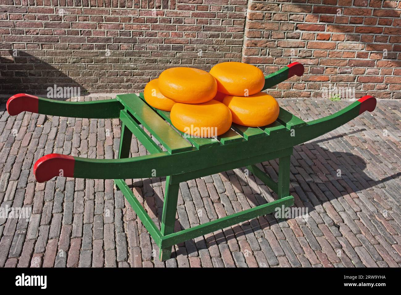 Wheels of Dutch Gouda cheese on traditional wooden barrow in Amsterdam