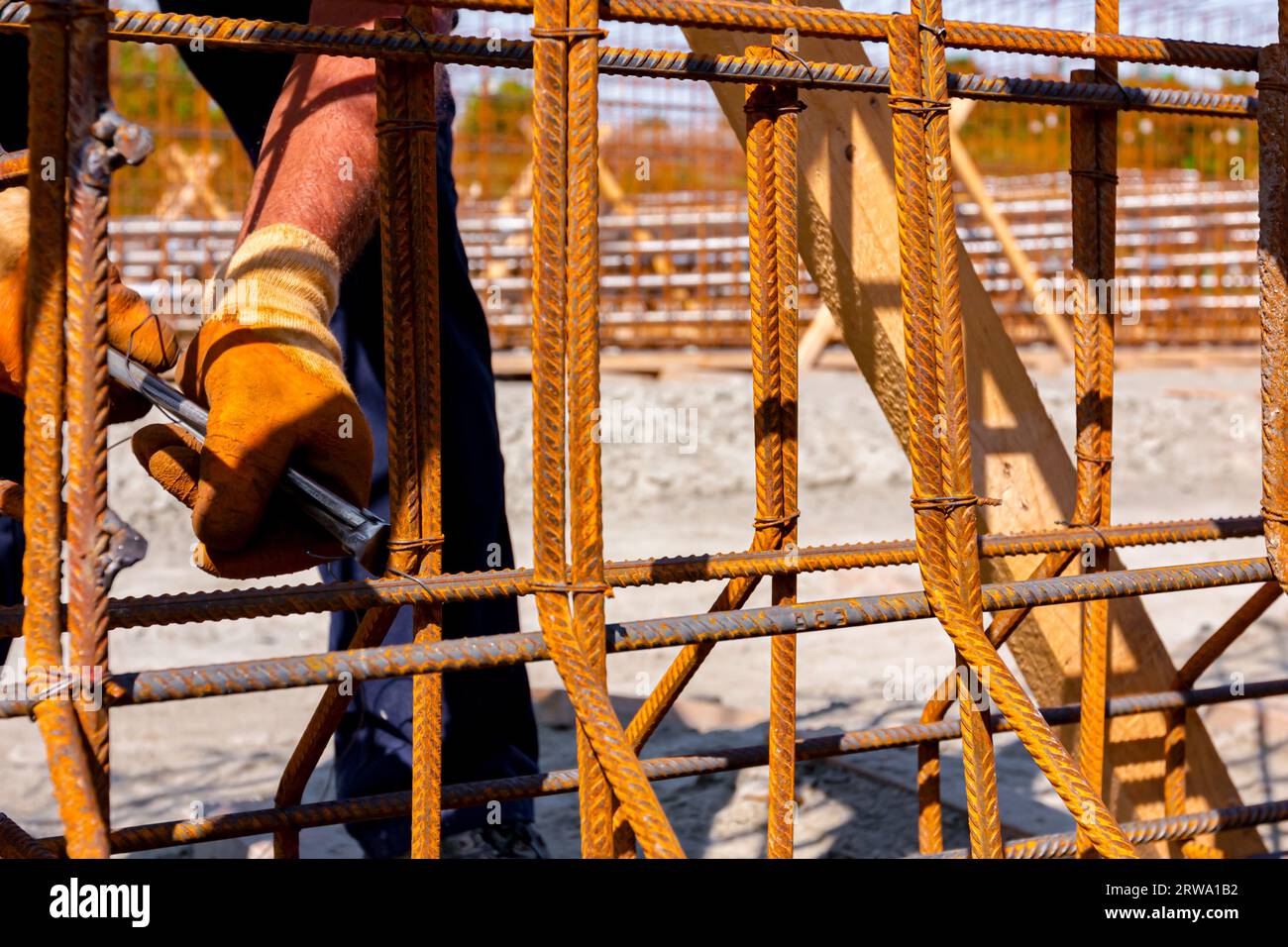 Worker is tying rebar with wire using pliers, to make a reinforcing