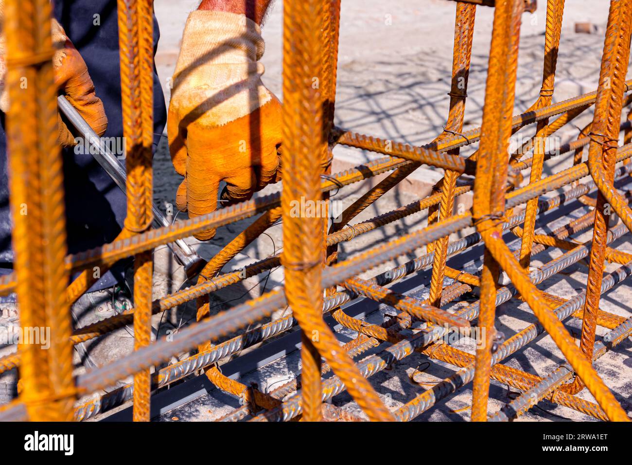 Worker is tying rebar with wire using pliers, to make a reinforcing