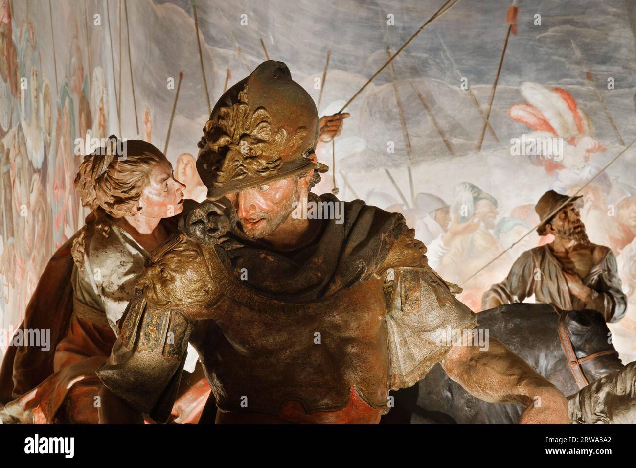 A Roman soldier and spectators of the spectacle stand by the cross of