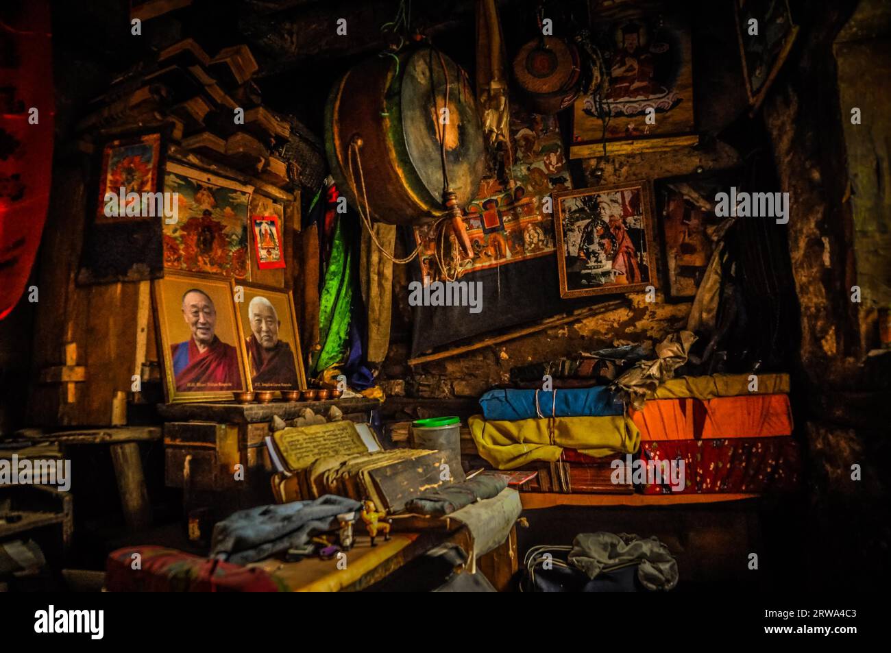 Dolpo, Nepal, circa June 2012: Photo of part of room with many things such as portraits of famous monks and people, large drum and colourful clothing Stock Photo