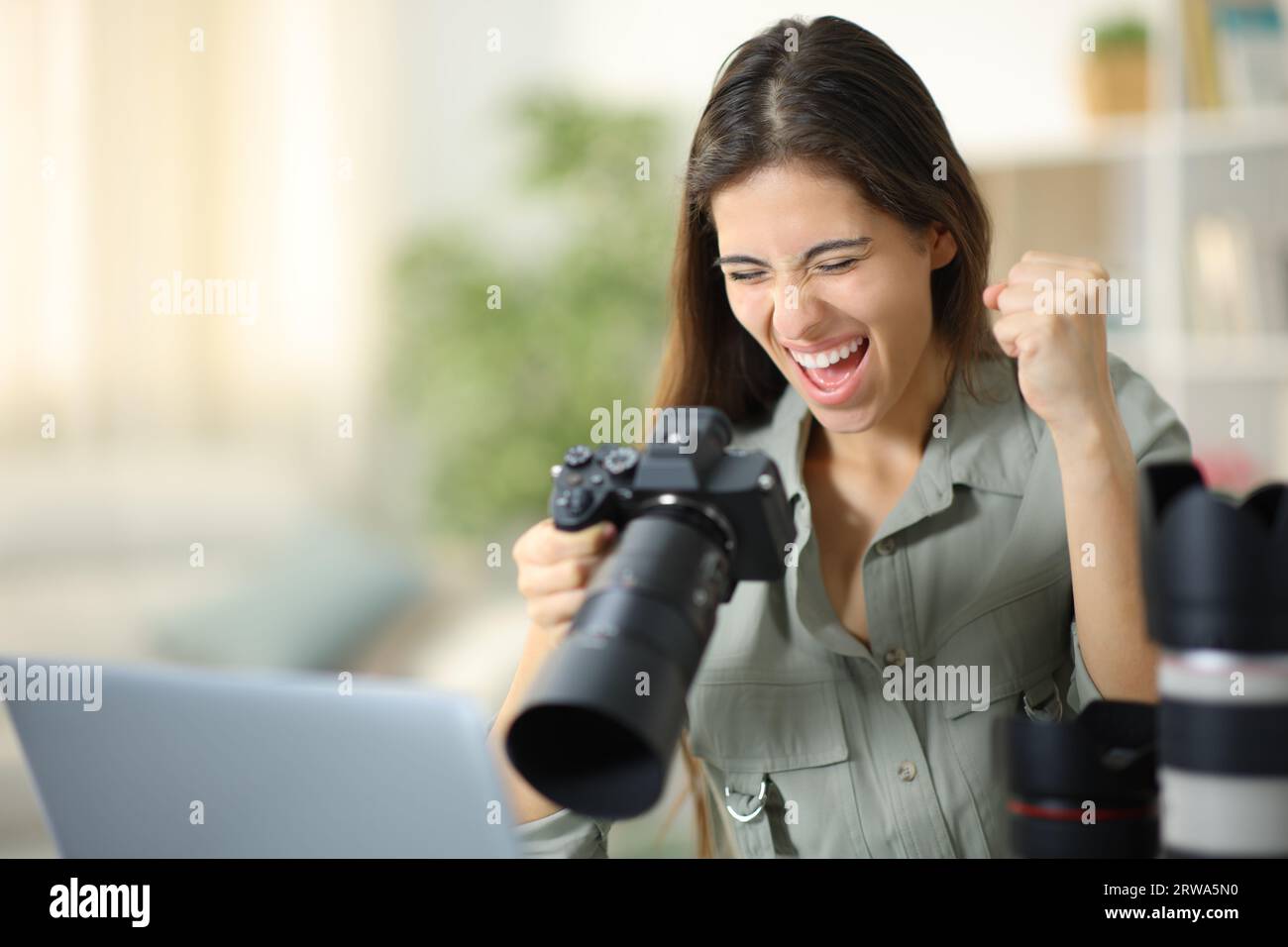 Excited photographer at home celebrating good result on camera Stock Photo