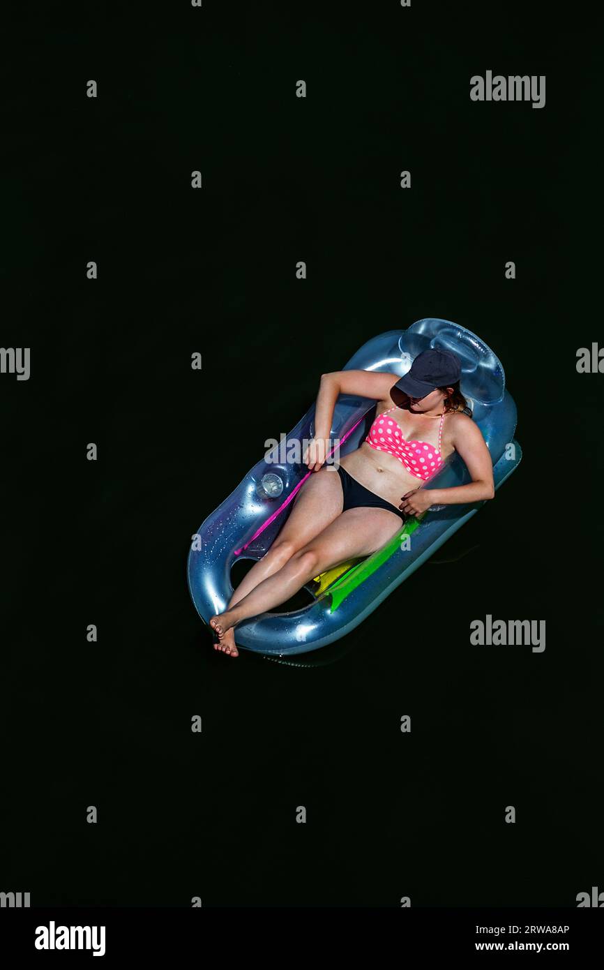 Looking down on a woman floating on an air mattress on the Russian River in Monte Rio, California. Stock Photo