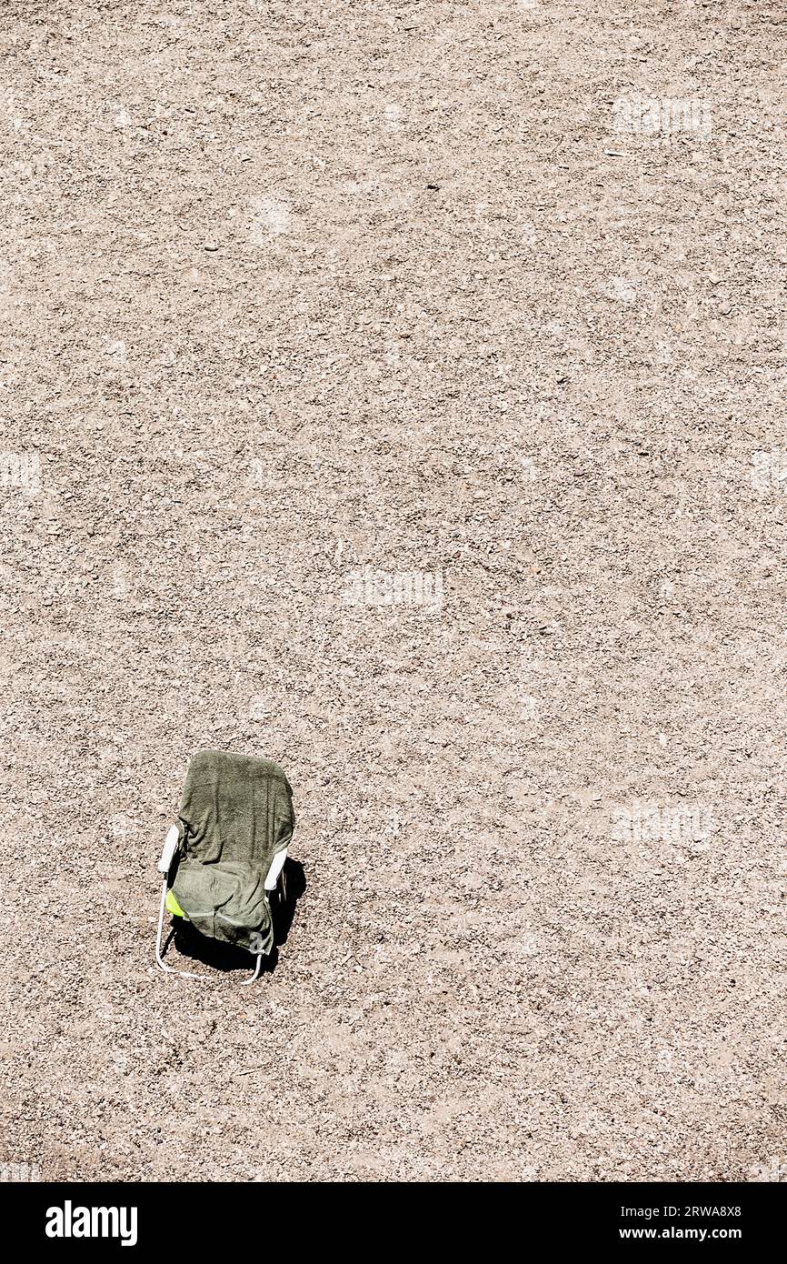 Empty chair and beach towel on the gravel beach of the Russian River in Monte Rio, California Stock Photo