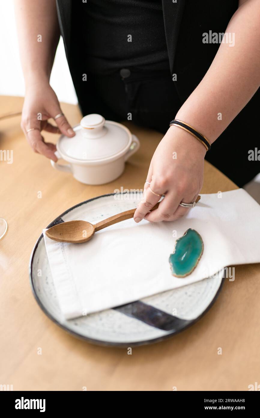 An interior designer styles a modern table setting Stock Photo