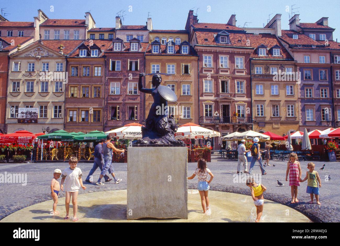 Poland, children play around the statue of the Mermaid of Warsaw at the Old Town Square in Warsaw. Stock Photo