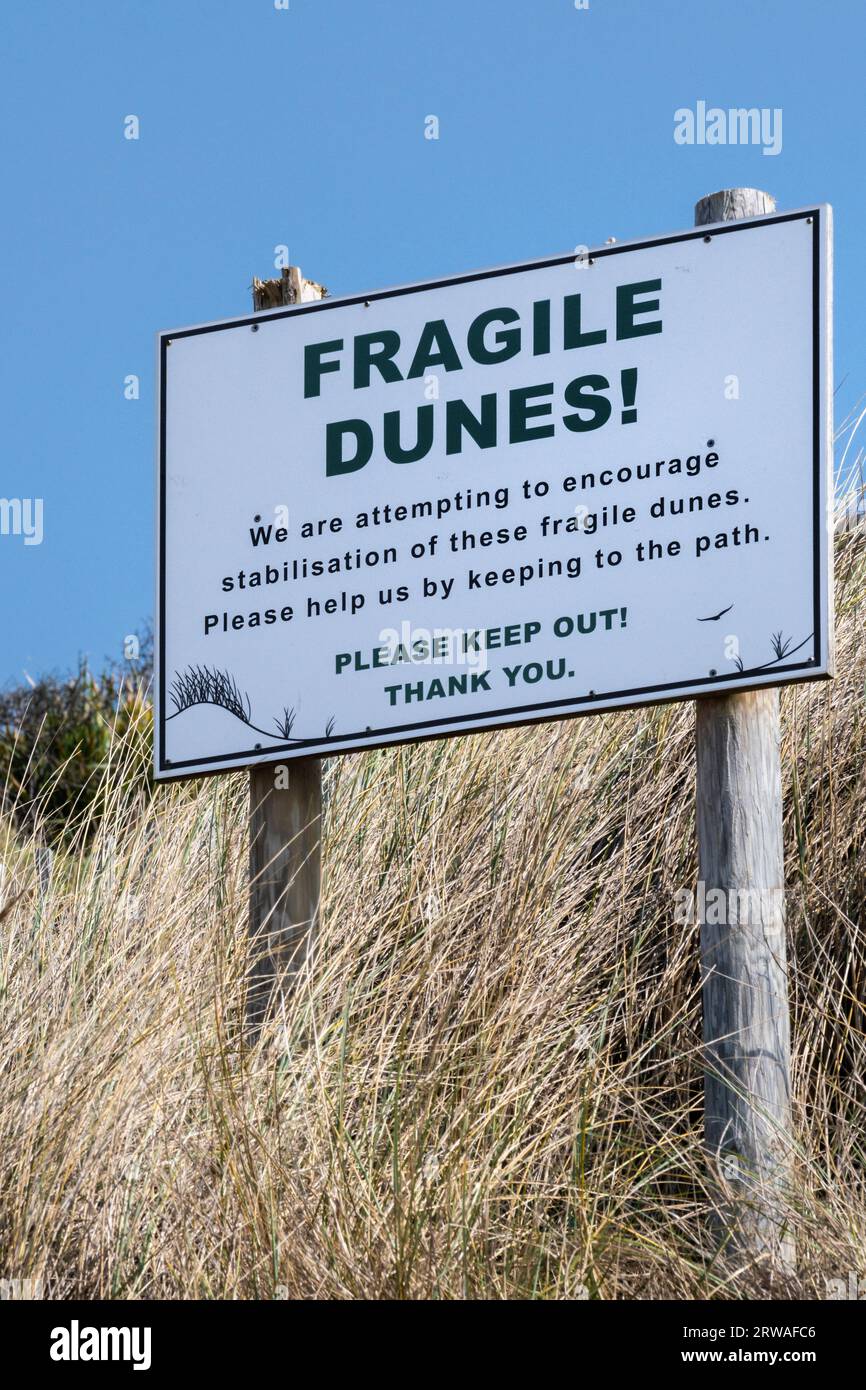 A sign warning of fragile dunes at Mawgan Porth in Cornwall in the UK. Stock Photo