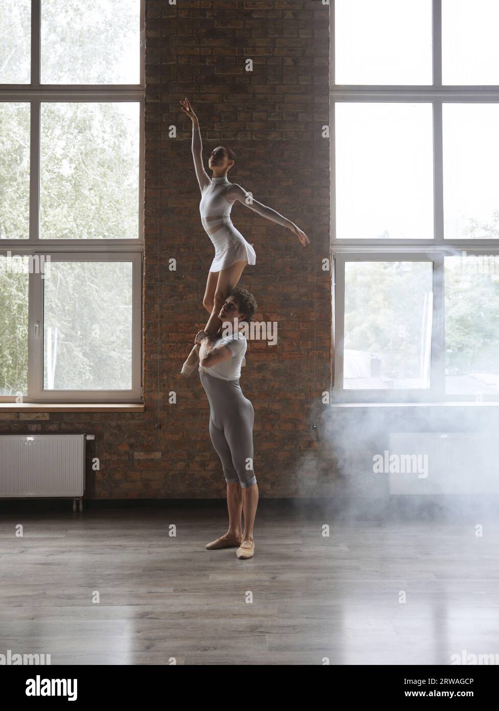Two athletic modern ballet dancers posing against studio background Stock Photo