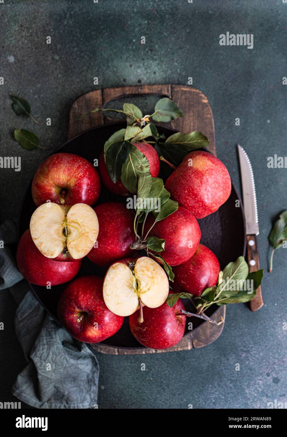 Bowl full of ripe red apples on dark back rustic table Stock Photo