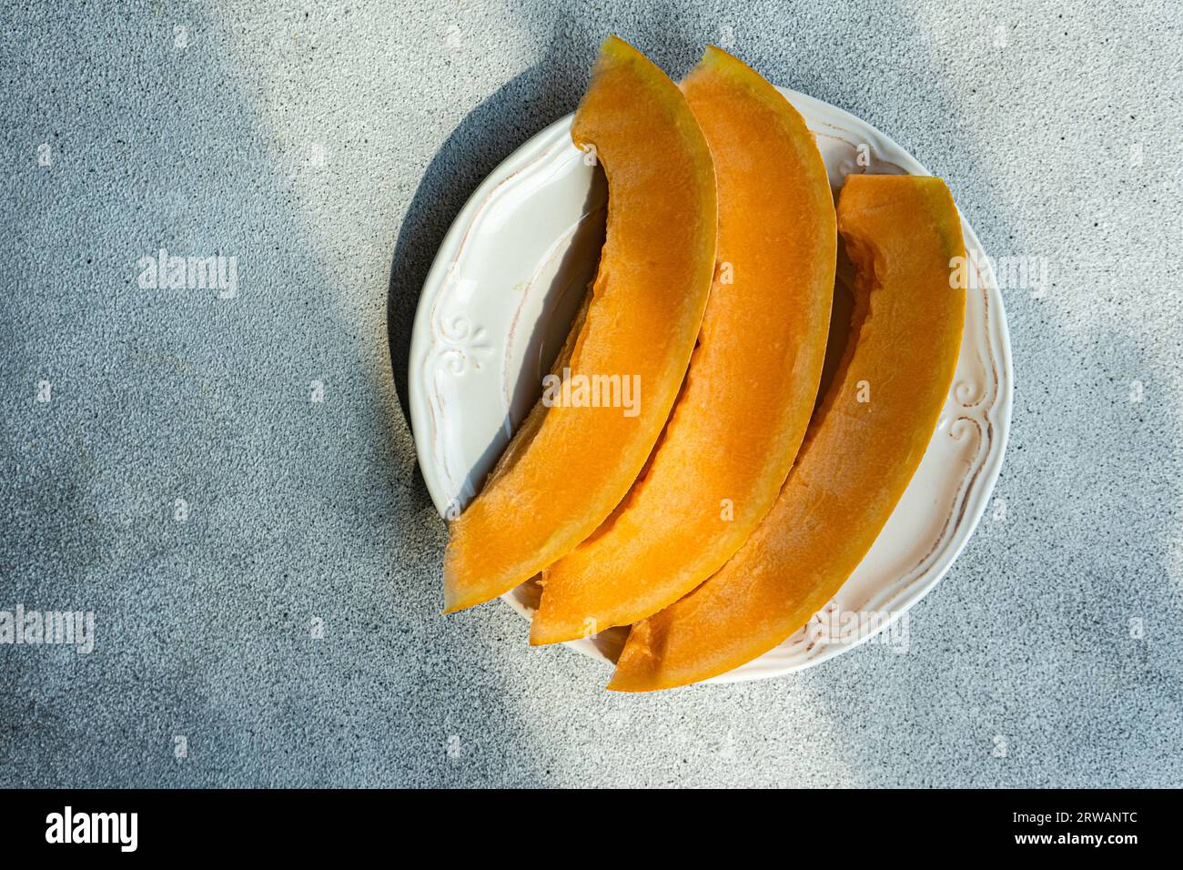 Tasty yellow organic melon slices on the plate Stock Photo