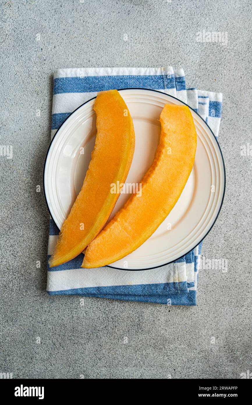 Tasty yellow organic melon slices on the plate Stock Photo