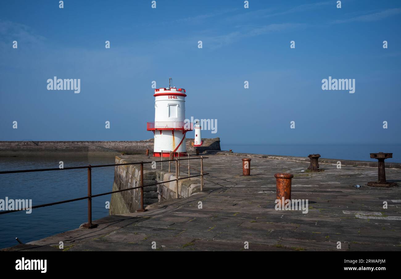 Two restored Victorian lighthouses at the entrance to Whitehaven Harbour, West Cumbria, UK Stock Photo