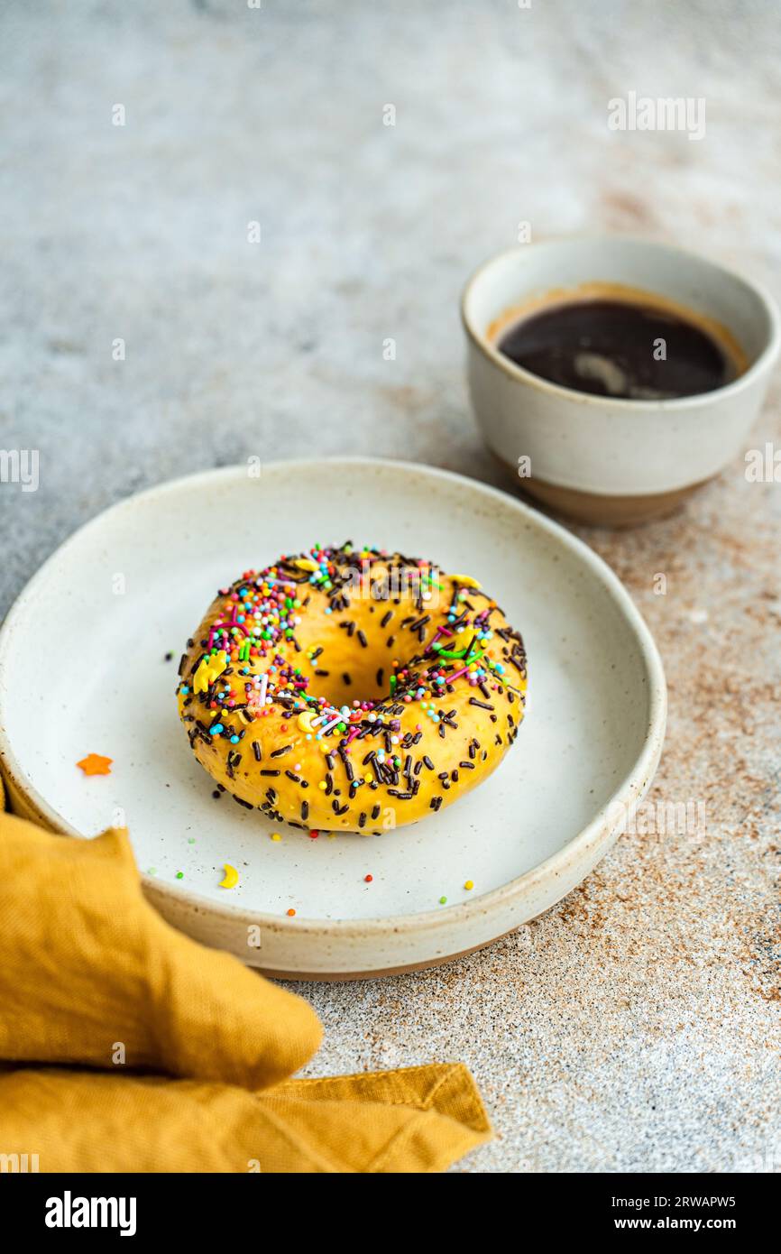 Banana donut cake and cup of black coffee on the table Stock Photo