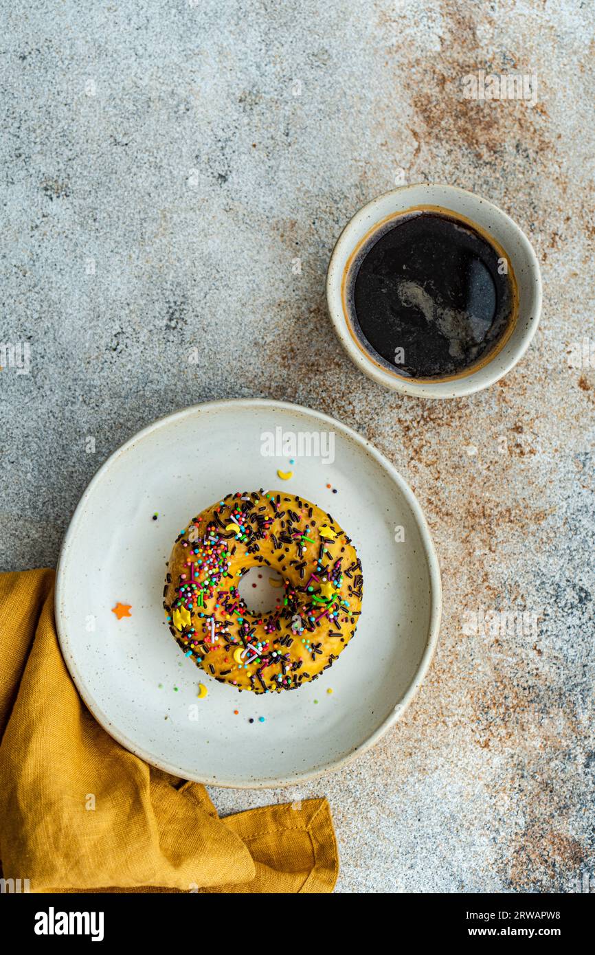 Banana donut cake and cup of black coffee on the table Stock Photo