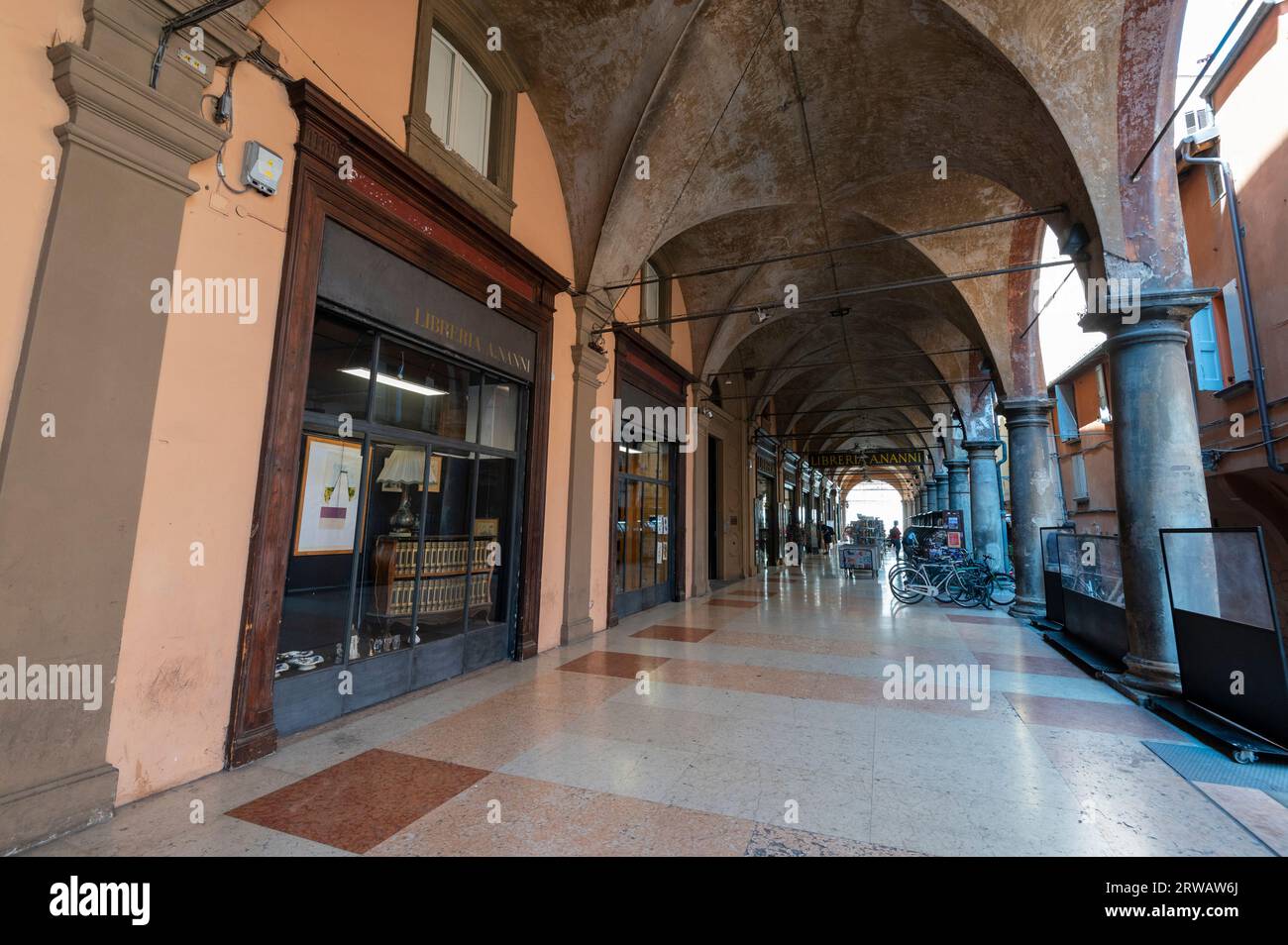 Libreria Nanni Bookshop on Via de' Musei, covered with a long high ceiling porticos or colonnades with a roof structure over a walkway supported with Stock Photo