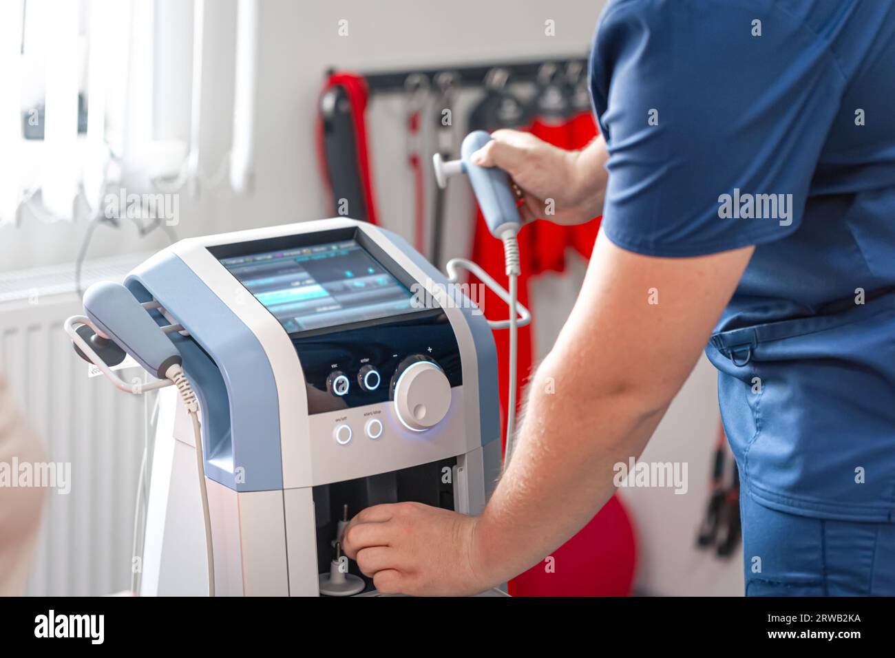 Physiotherapist doctor uses medical equipment for effective pain ...