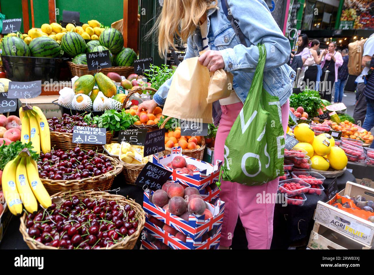 London, England, UK. Borough Market, Southwark. Woman shopping at a fruit stall. Stock Photo