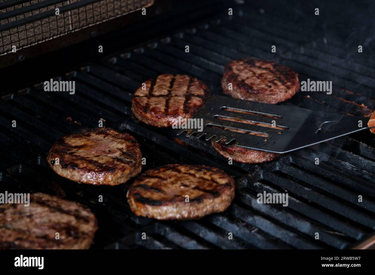 BBQ burgers prepared on barbecue fire flame grill with beef meat Stock ...