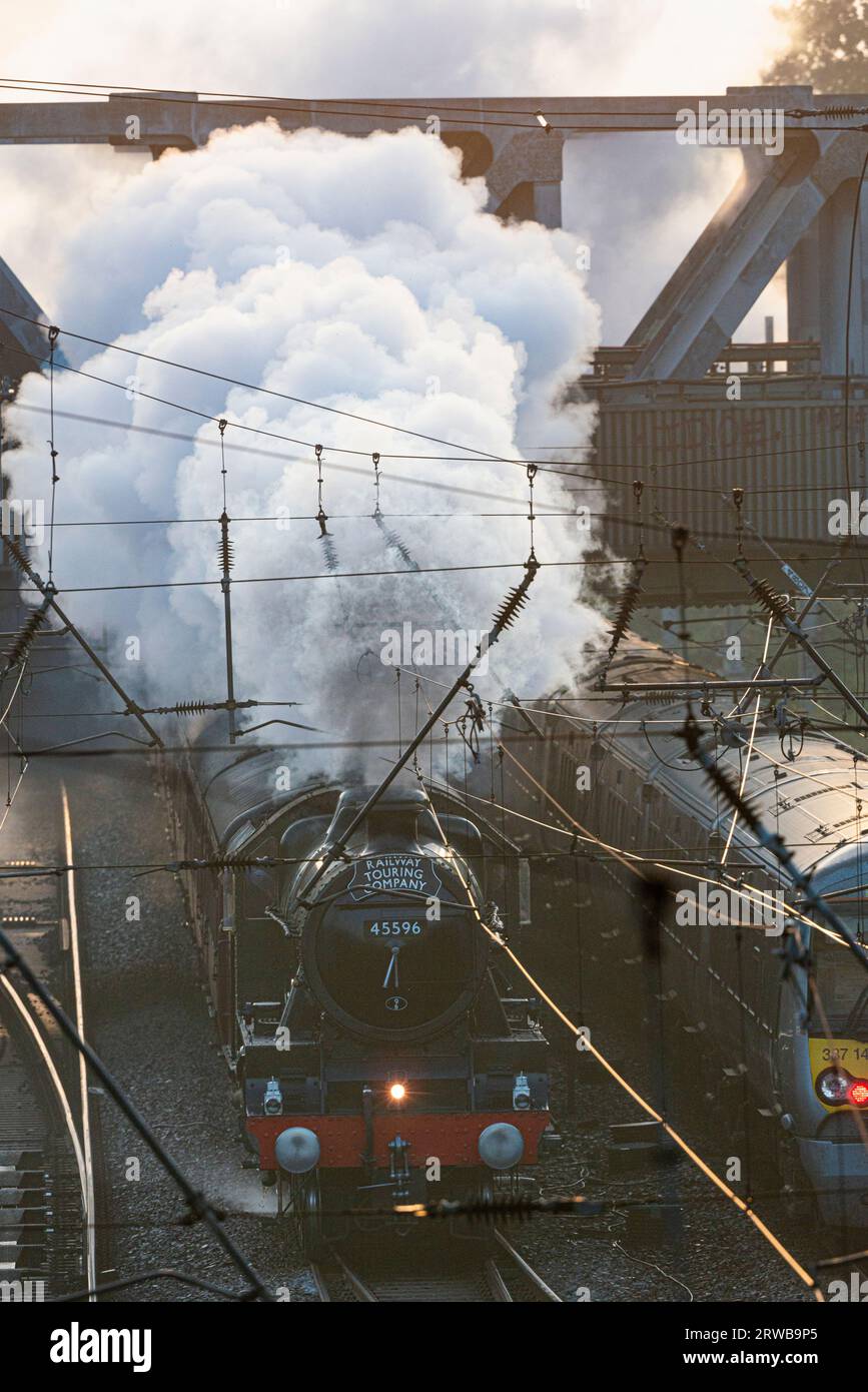 Old and newer. Steam train LMS Jubilee Class 5596 Bahamas heads west out of London, passing an eastbound Class 387 electric train. Ealing,  London Stock Photo
