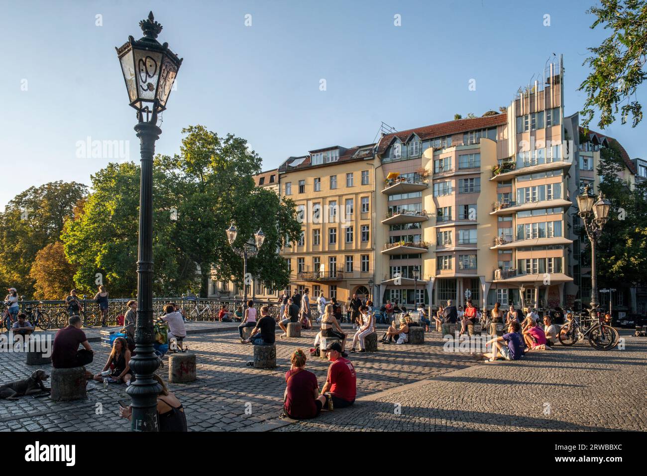 Junge Leute sitzen in Gruppen an der Admiralsbrücke in Kreuzberg, Berlin Stock Photo