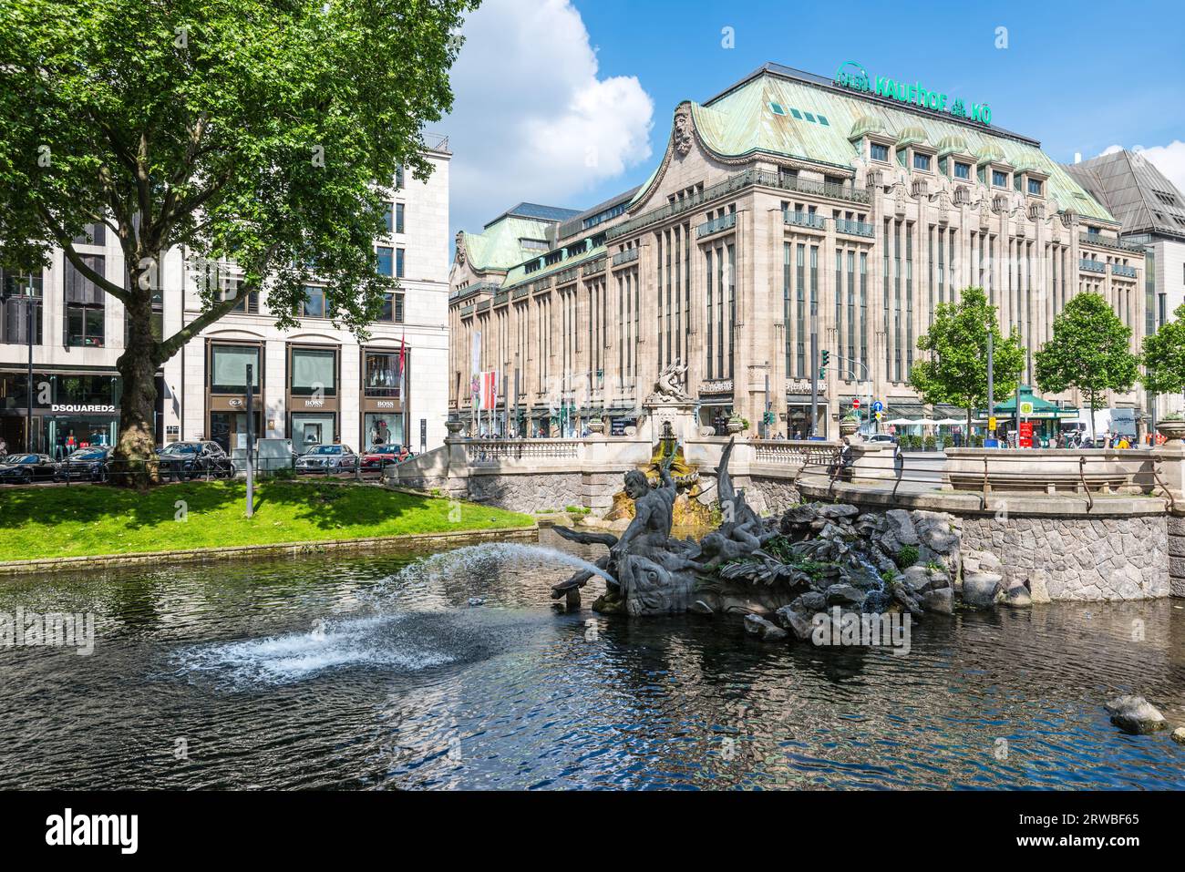 Dusseldorf, Germany - June 2, 2022: Outdoor view of Tritonenbrunnen fountain and beautiful waterside area at Konigsallee, famous shopping street, and Stock Photo
