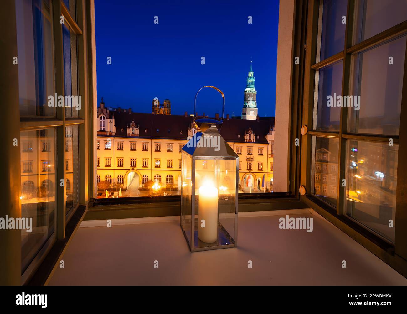 Lamp with a candle in the window. View of the market square Stock Photo