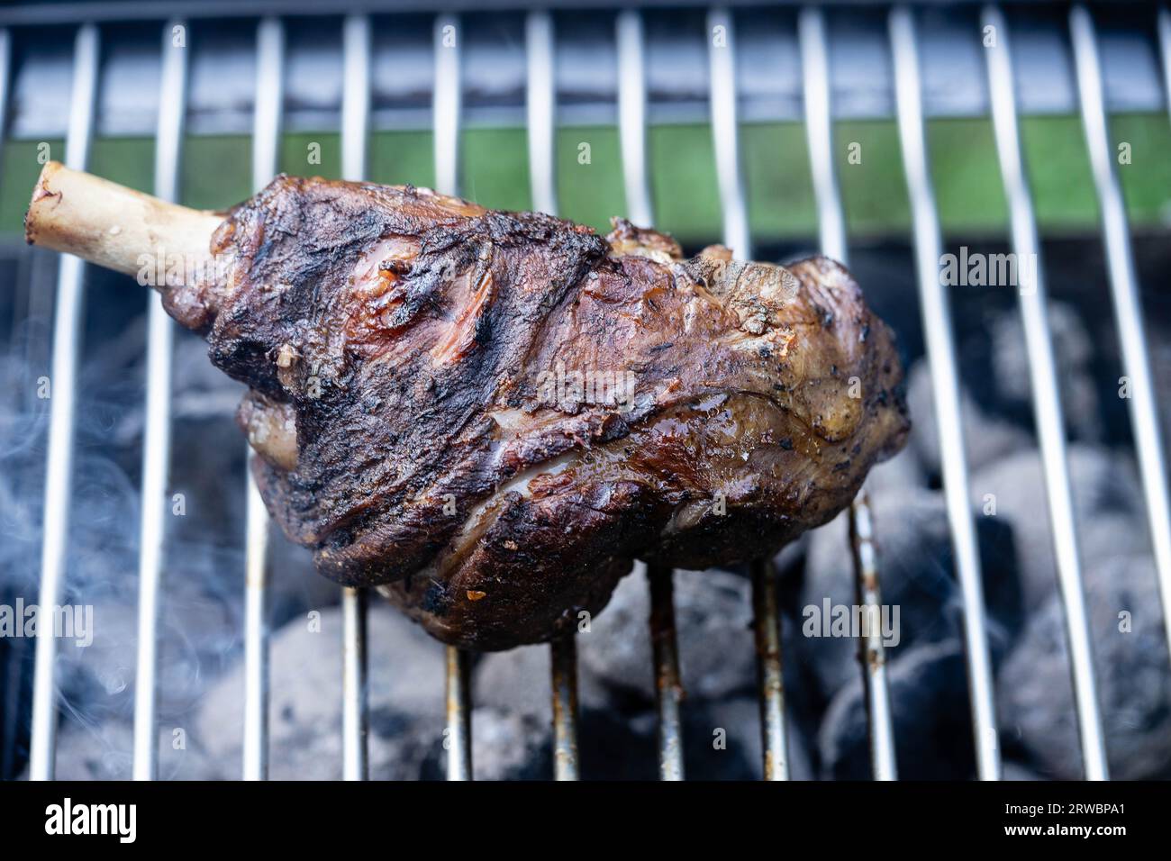 Grilled lamb shank from the charcoal grill with bulgur and garlic cream