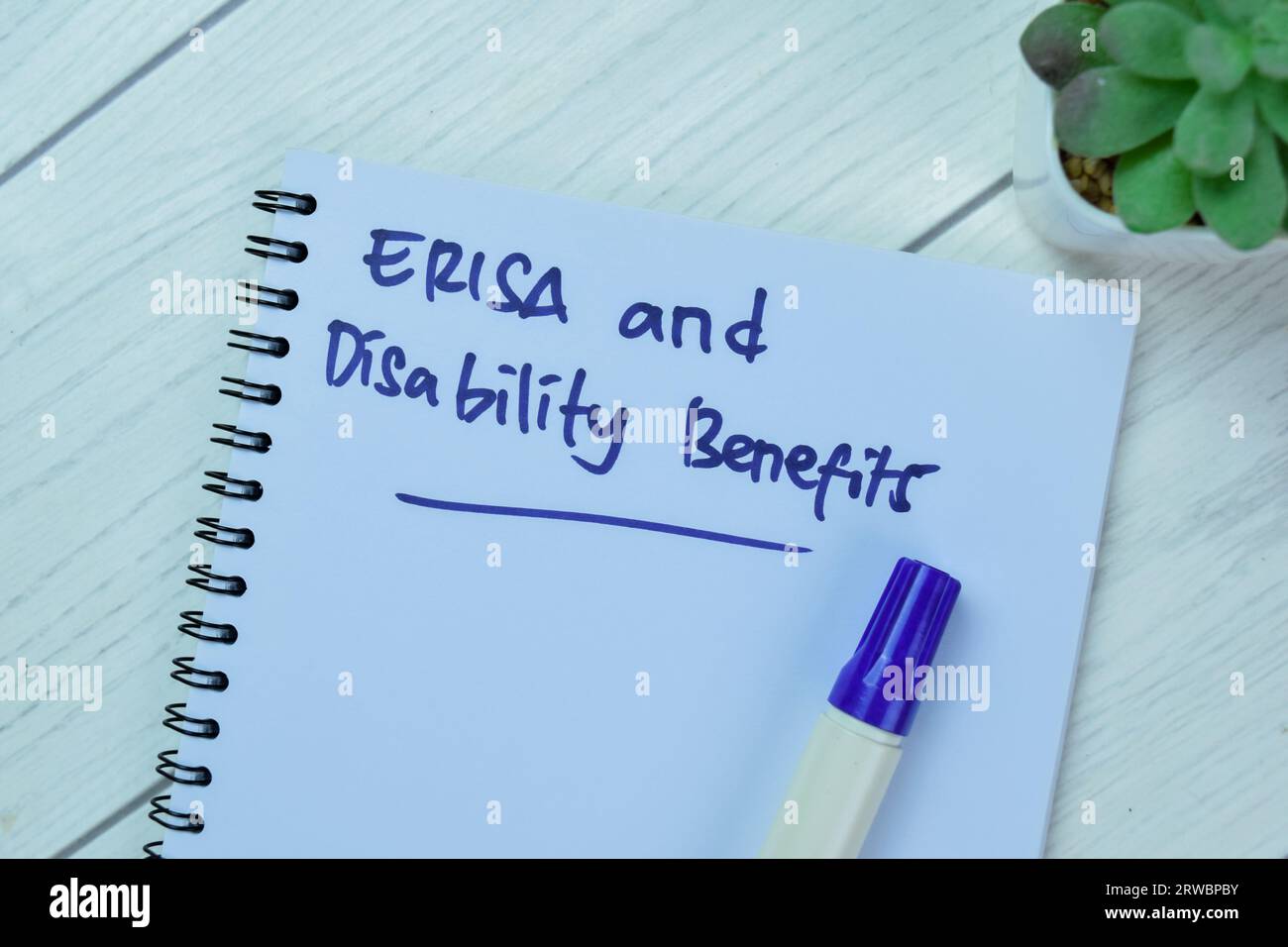Concept of ERISA and Disability Benefits write on book isolated on Wooden Table. Stock Photo