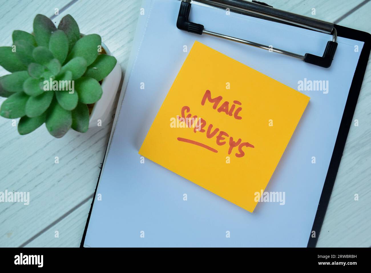 Concept of Mail Surveys write on sticky notes isolated on Wooden Table. Stock Photo