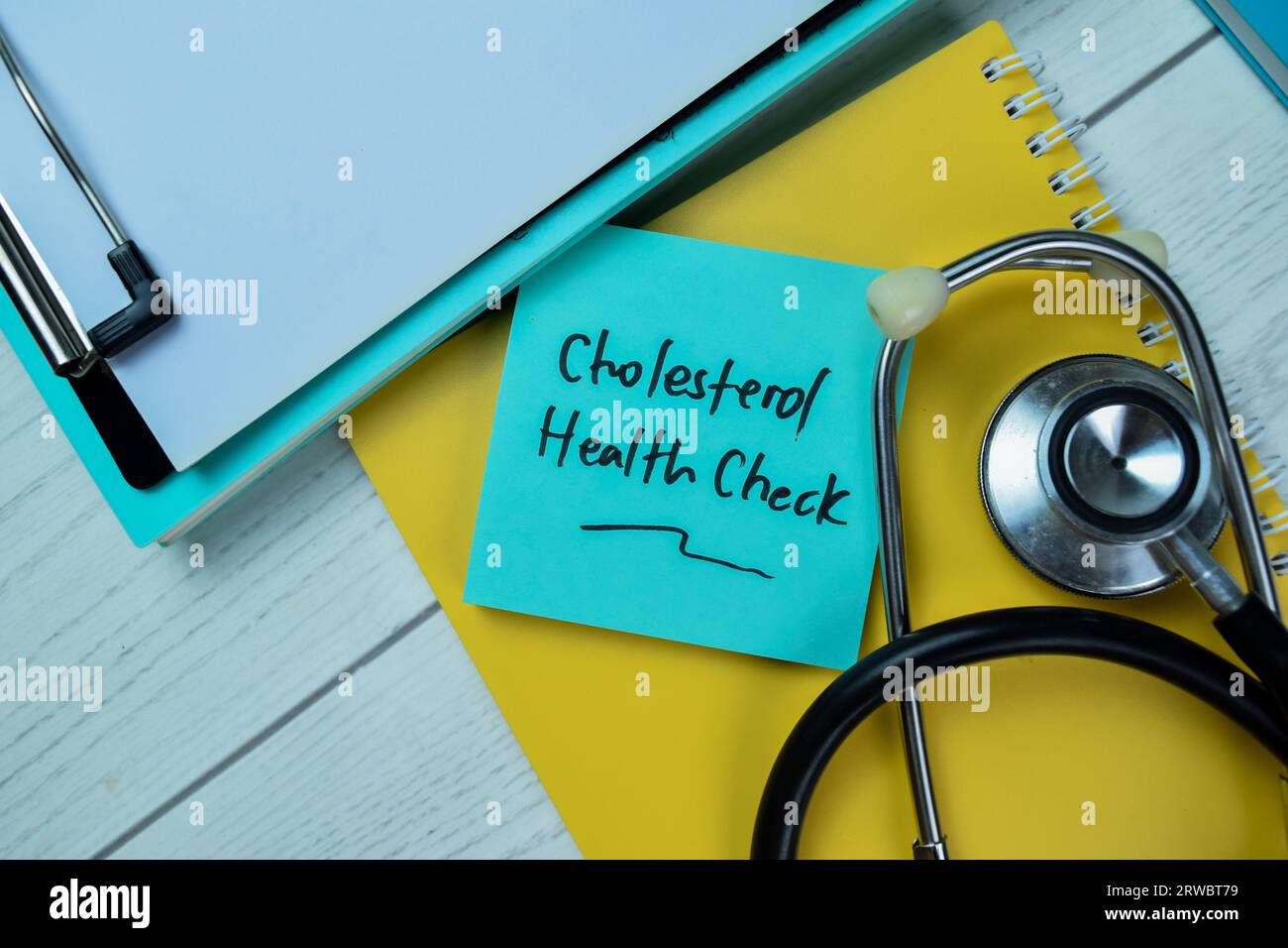 Concept of Cholesterol Health Check write on sticky notes with stethoscope isolated on Wooden Table. Stock Photo