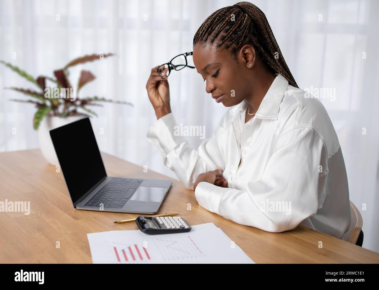 Fatigued young african woman working at office Stock Photo
