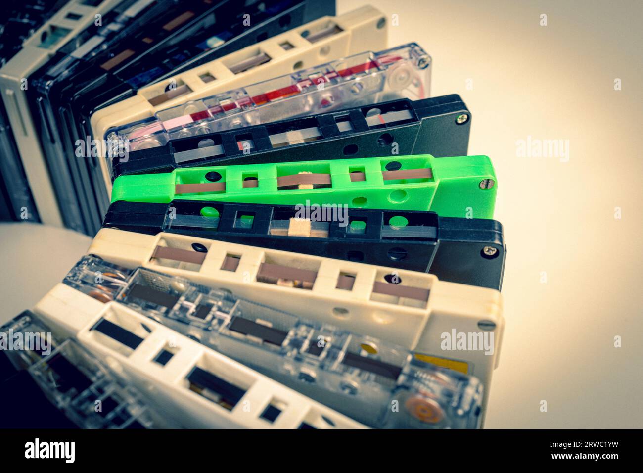 background with old audio cassettes of various colours, analogue music concept. Stock Photo