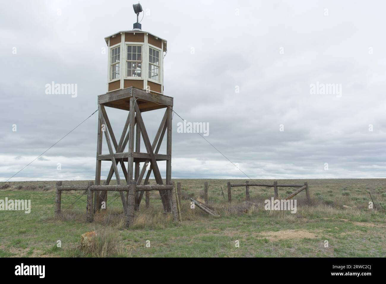 Wooden guard tower stands watch along peripheral  of Granada  Relocation Center internment Camp under stormy sky Stock Photo