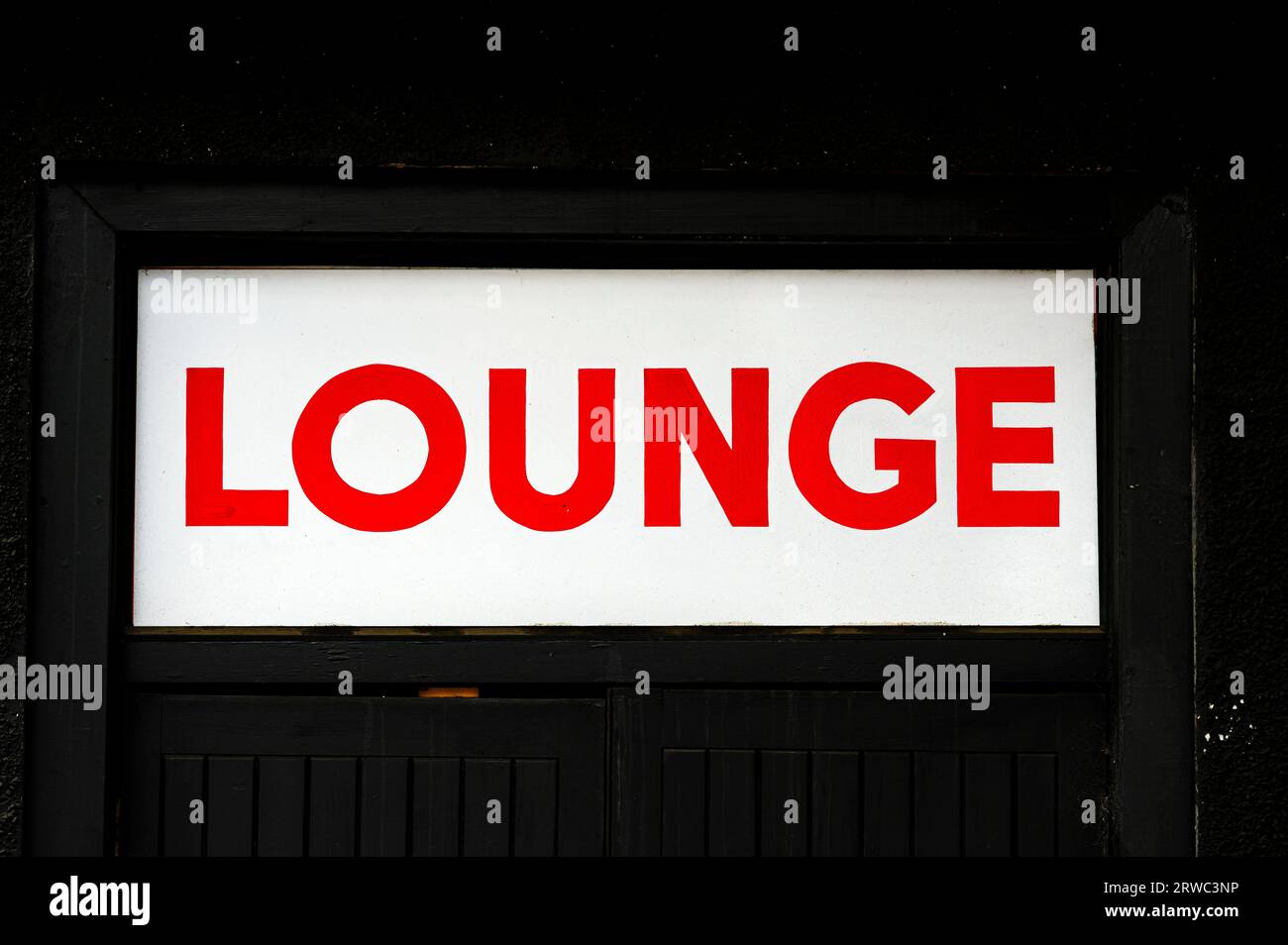 A red Lounge sign above the entrance to a pub Stock Photo
