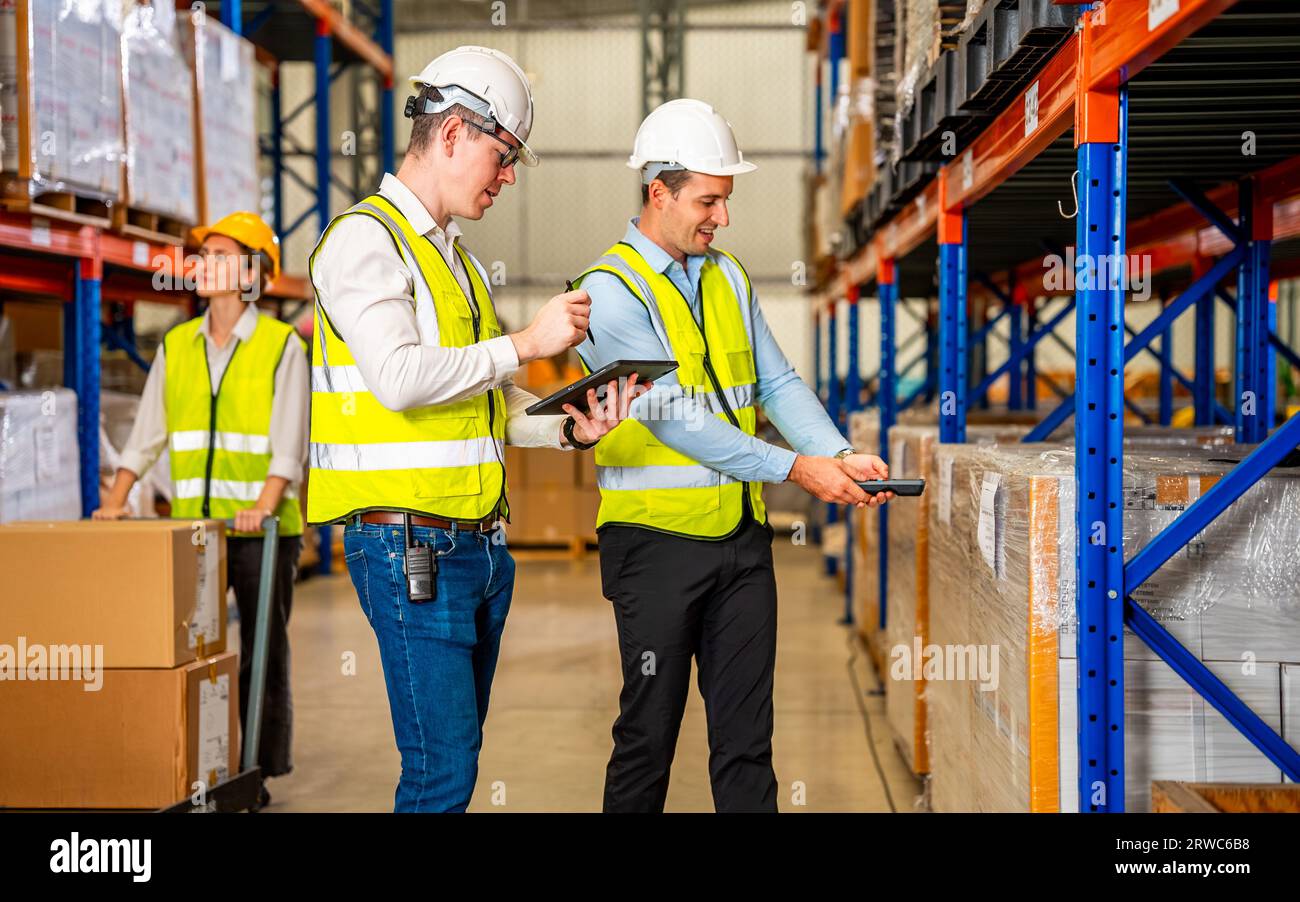 Warehouse workers talking together checking goods in storage Stock Photo