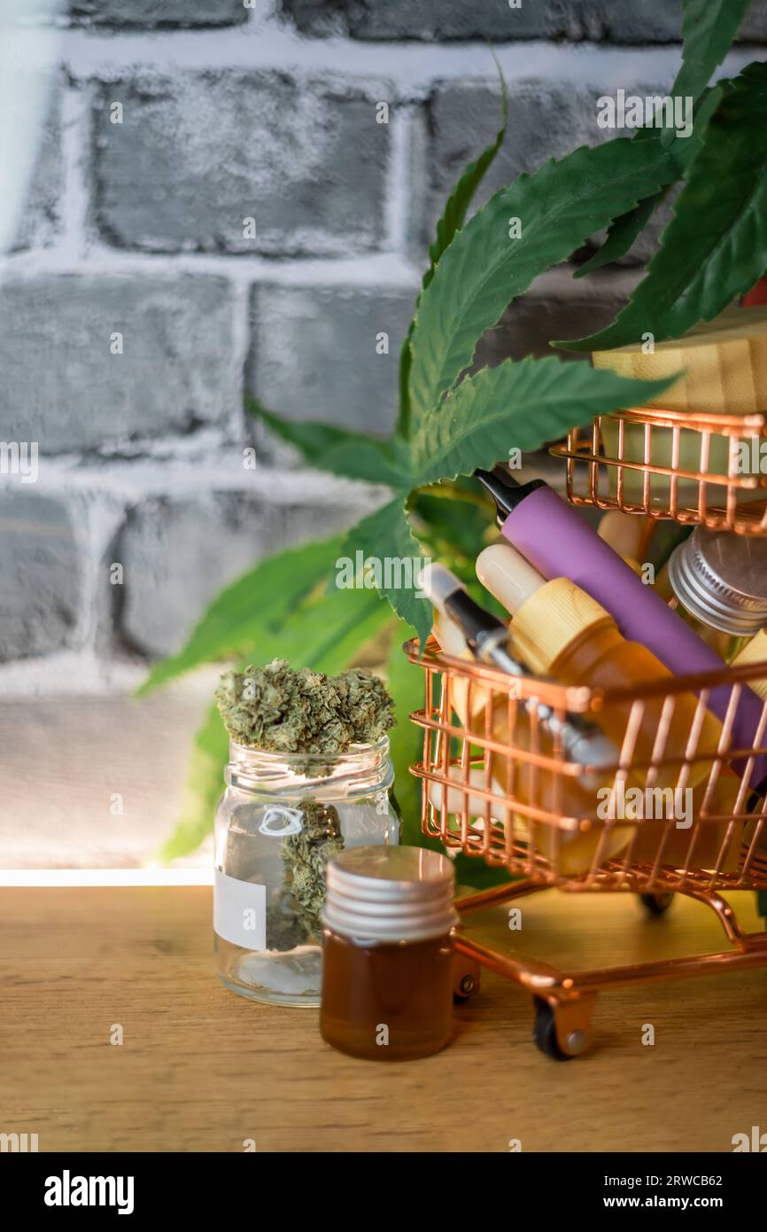 Mini shopping cart with various Medical Cannabis products on table, Shopping purchase concept of Marijuana supplements Stock Photo