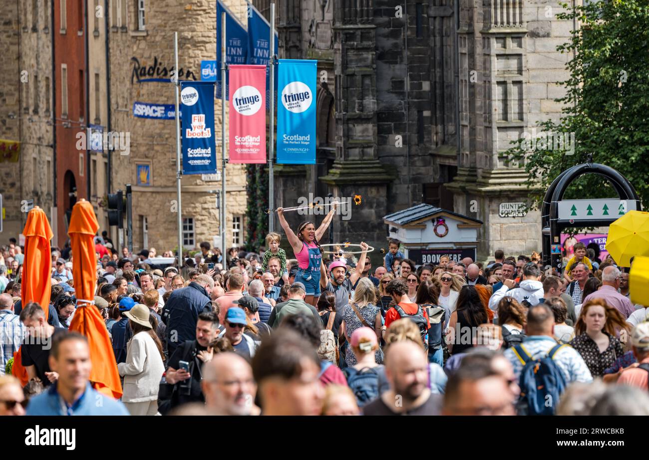 Crowd watching street performer twirling fire hoop, Edinburgh Festival Fringe, Royal Mile, Scotland, UK Stock Photo