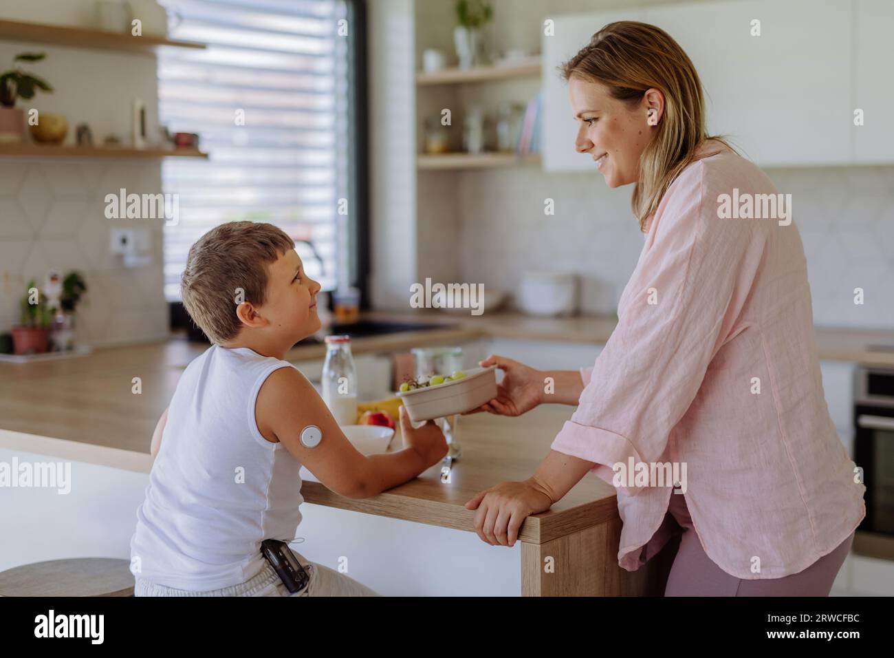 Diabetic boy with a continuous glucose monitor is careful with his diet