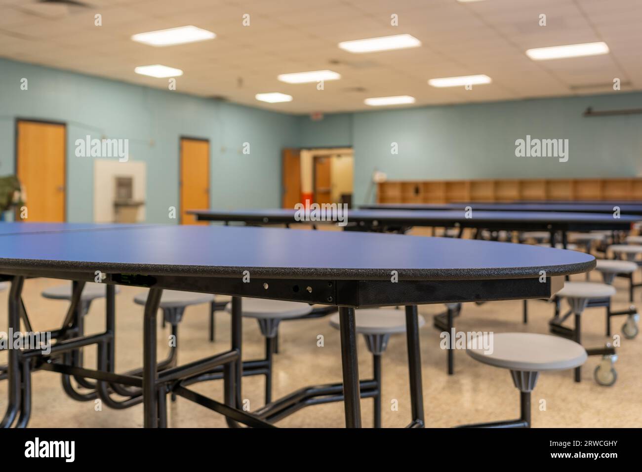 Blue folding table with attached seats in a school cafeteria. Stock Photo