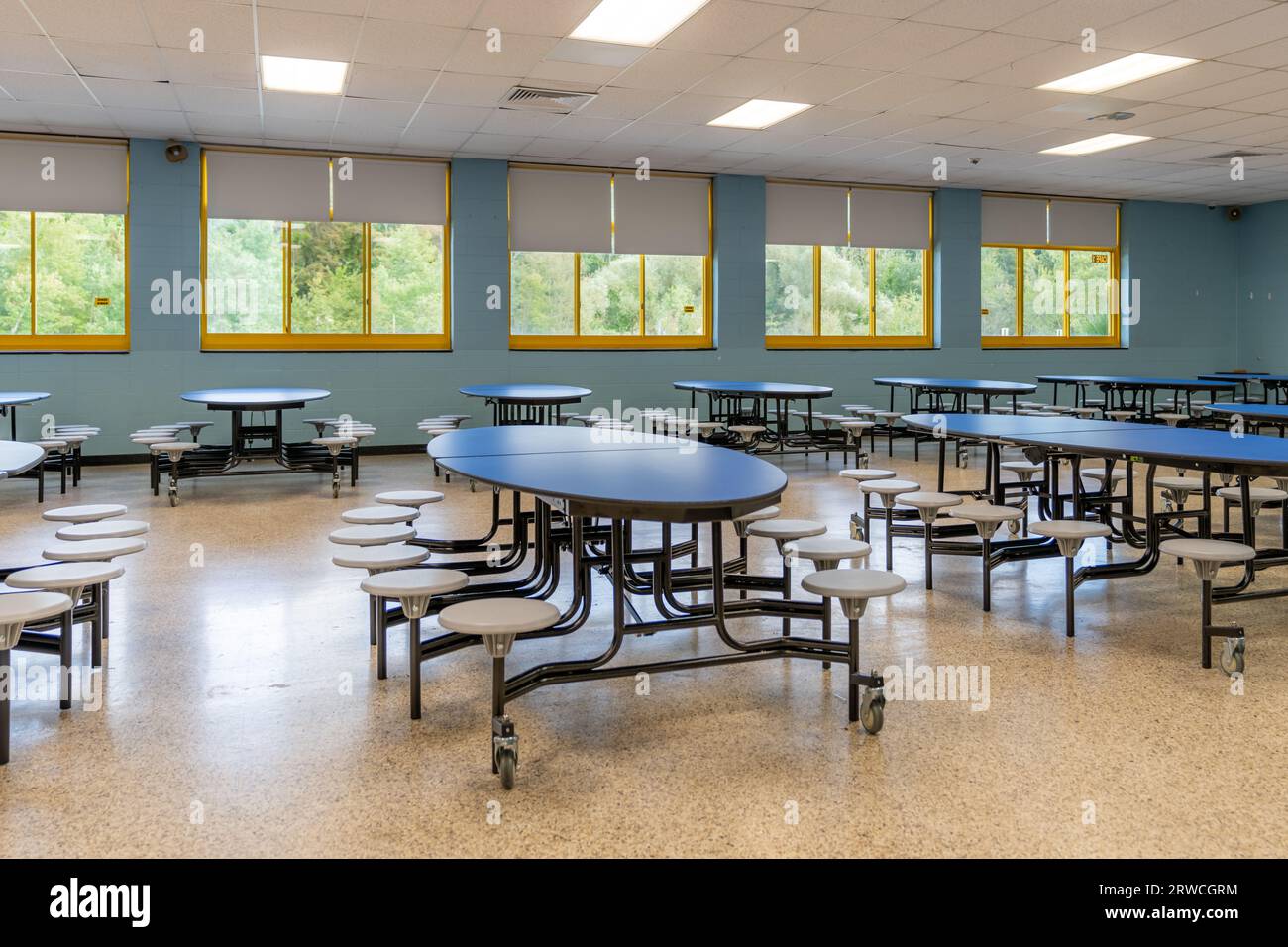 Blue folding table with attached seats in a school cafeteria. Stock Photo