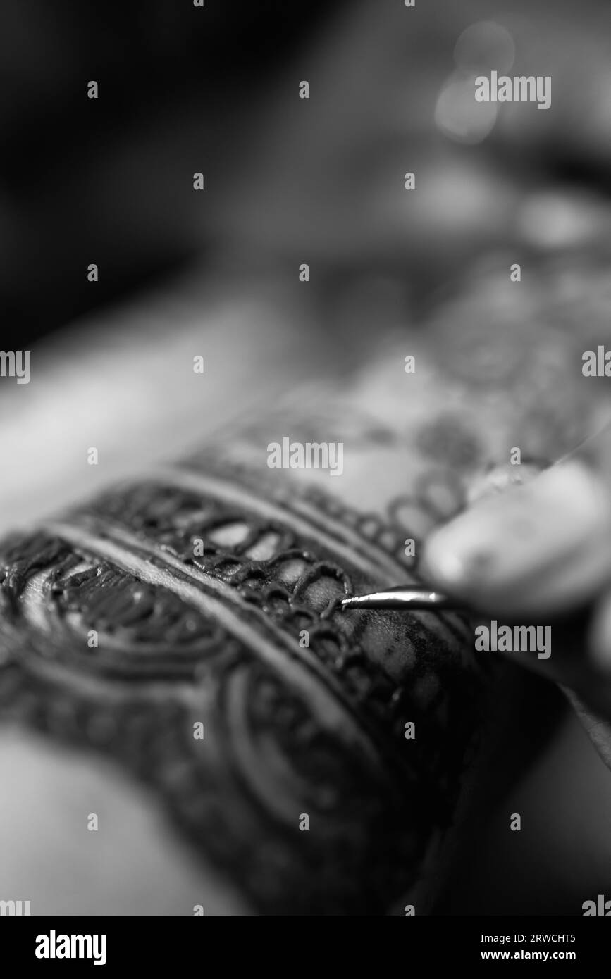 Applying Beautiful henna art on hands. Bridal design. Wedding Mehendi