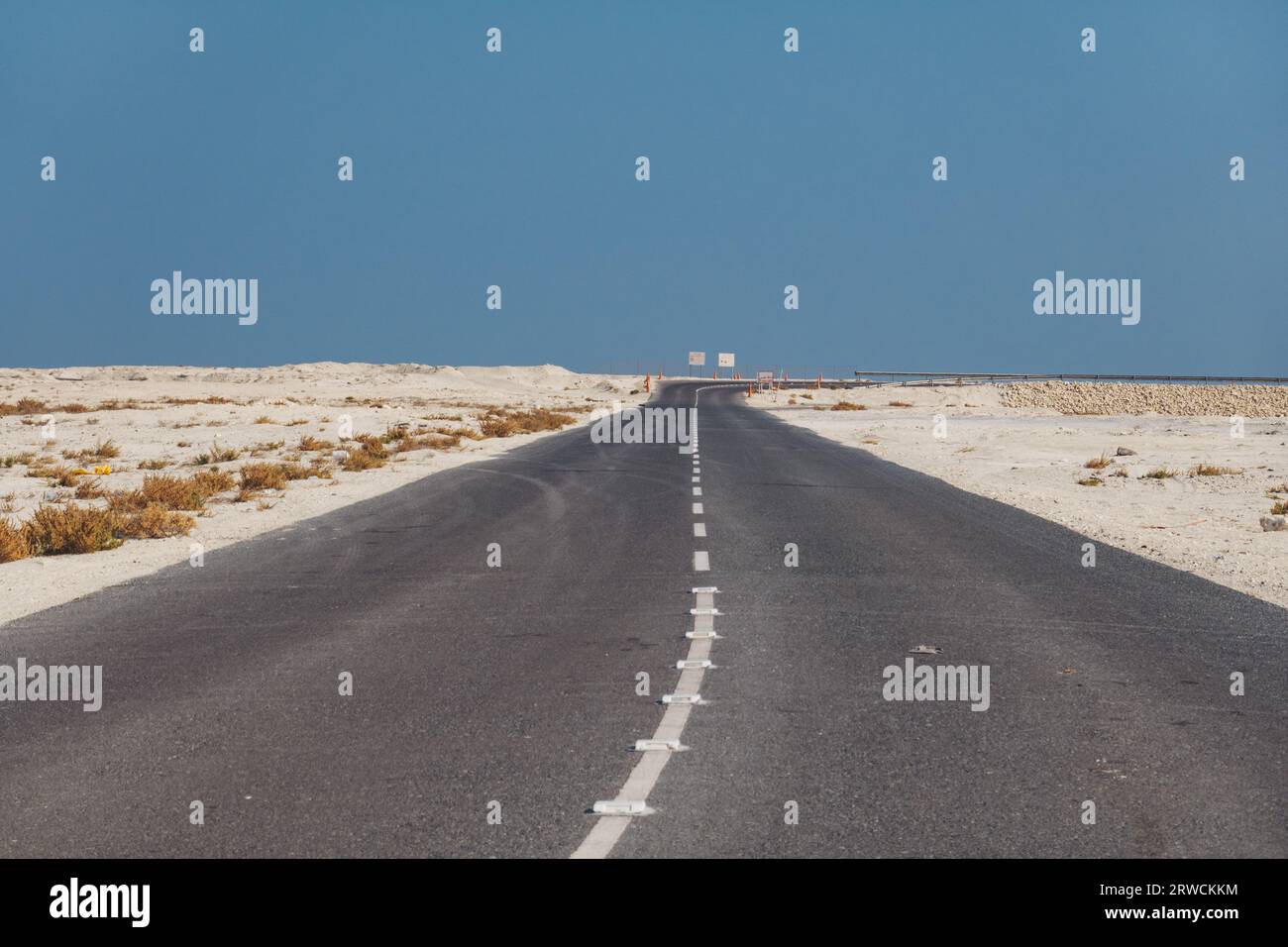 an empty highway spans across the desert in southern Bahrain Stock Photo