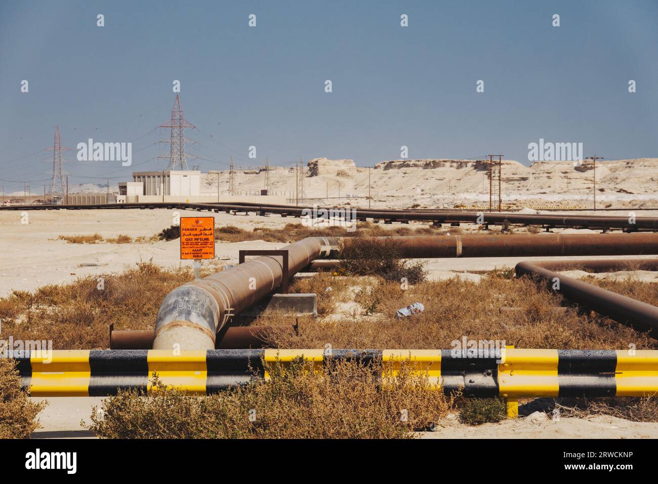 natural gas pipelines with warning signs sprawl across the desert in