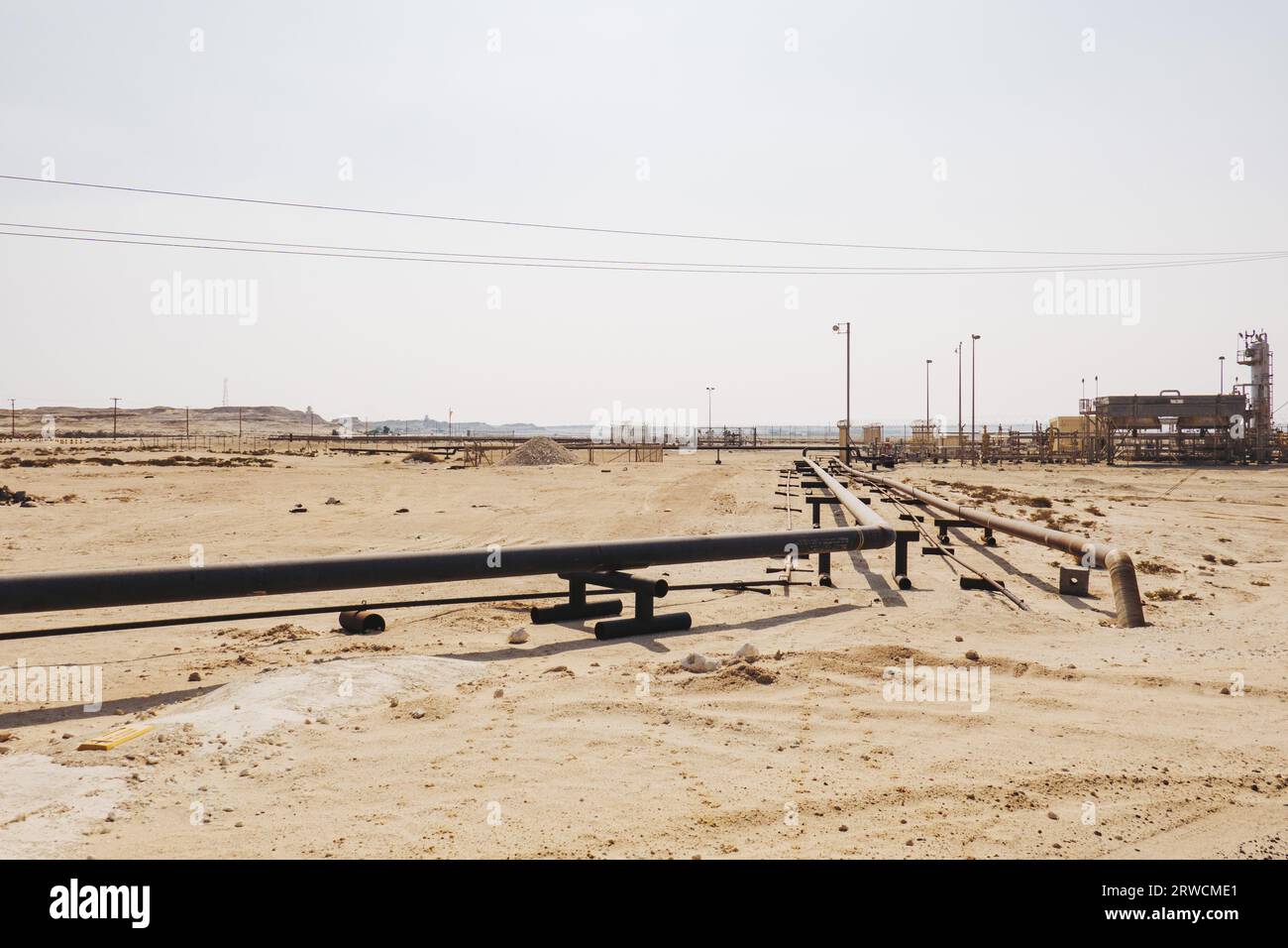 a natural gas pipeline runs across desert sand in the Middle Eastern