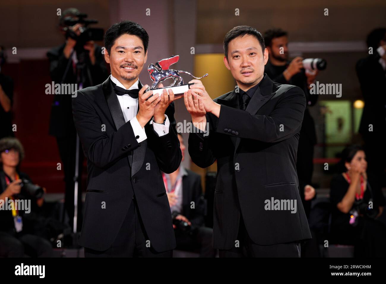 Venice, Italy. 18th Sep, 2023. Hitoshi Omika and Ryusuke Hamaguchi pose with the Silver Lion Grand Jury Prize Award for 'Evil Does Not Exist during attend the winner's photocall at the 80th Venice International Film Festival (Photo by Daniele Cifala/NurPhoto) Credit: NurPhoto SRL/Alamy Live News Stock Photo
