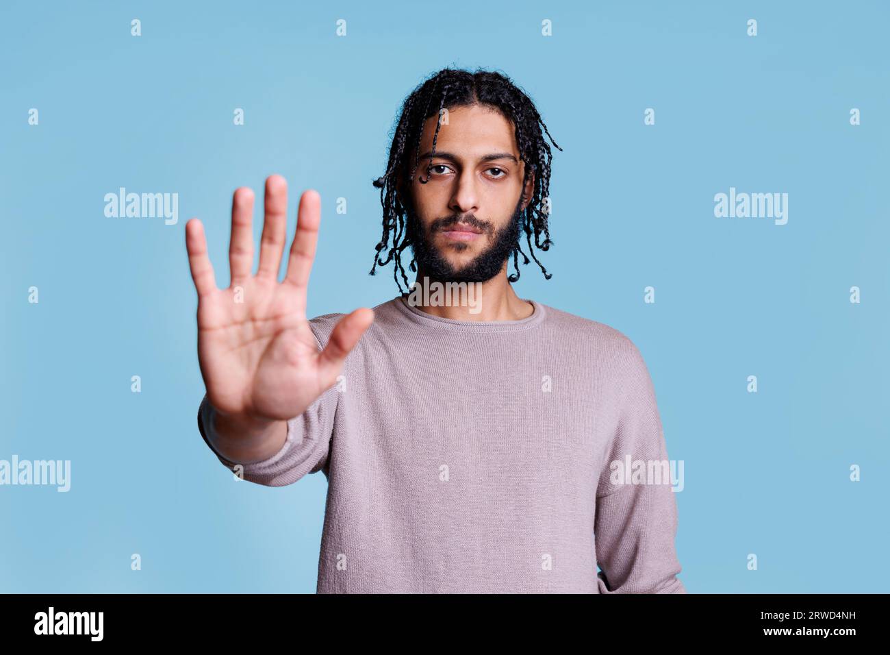 Arab man making stop gesture with hand and looking at camera with ...