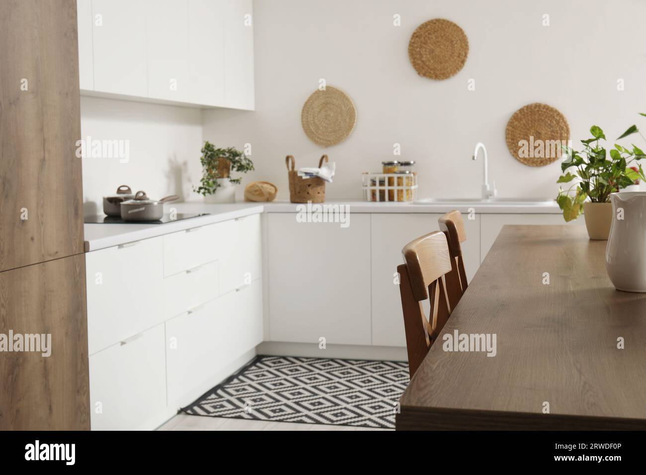 Interior of modern kitchen with white counters and island table Stock ...