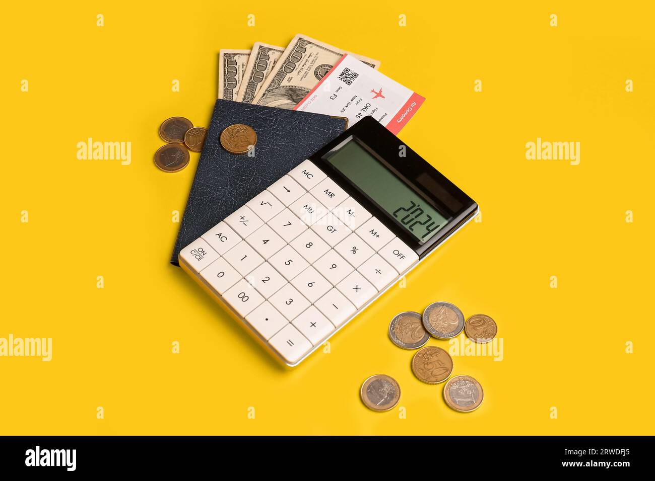 Calculator with number 2024, passport, flight ticket and cash on yellow