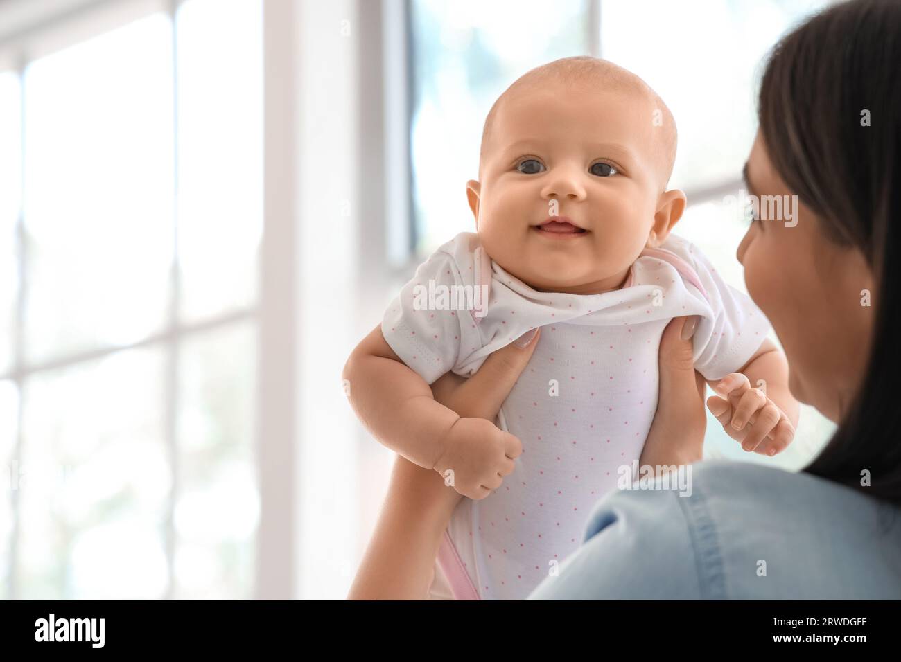 Young woman with her baby at home, closeup Stock Photo