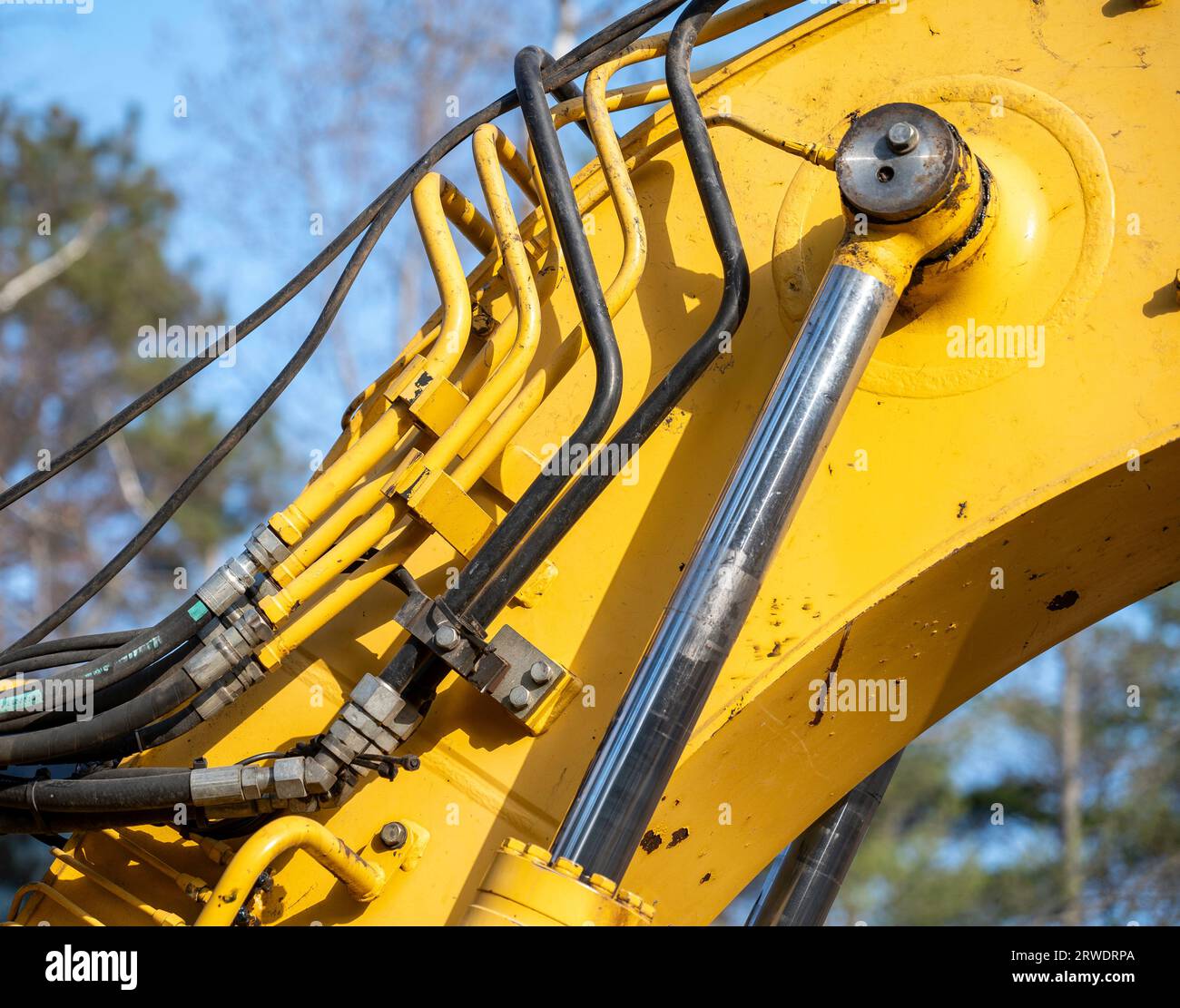 Closeup of the hydraulics pipes and fittings and cylinder on a working